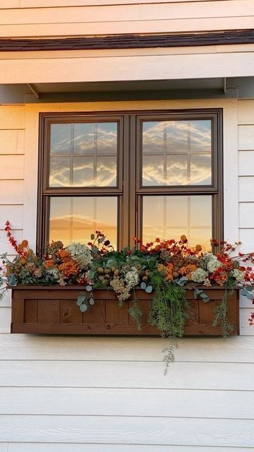 a window box filled with flowers on the side of a house