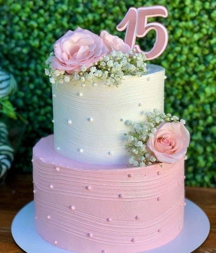 a pink and white cake sitting on top of a table