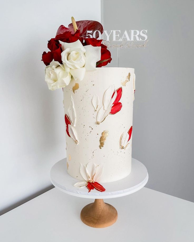 a white cake with red and white flowers on it