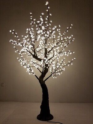 a lighted tree in the shape of a lamp with white lights on it's branches