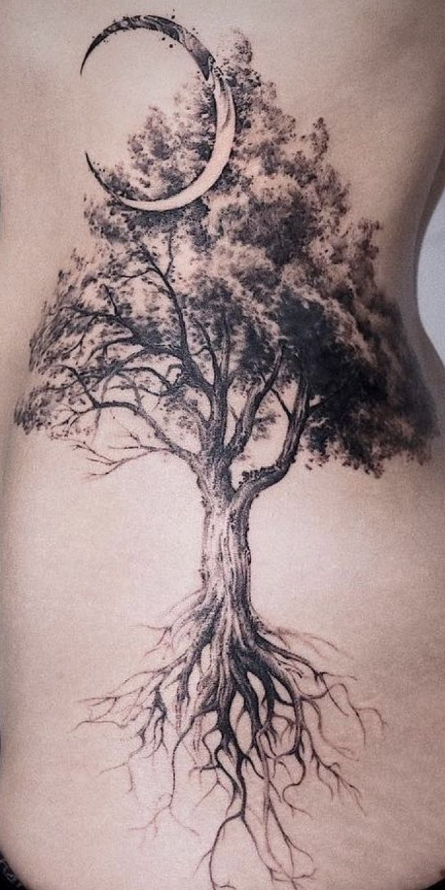 a woman with a tree and moon tattoo on her stomach