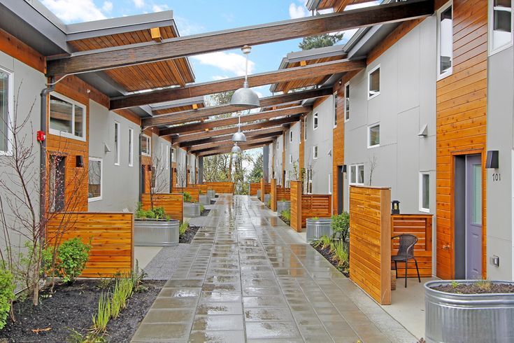 the walkway is lined with wooden buildings and potted plants on either side of the walkway