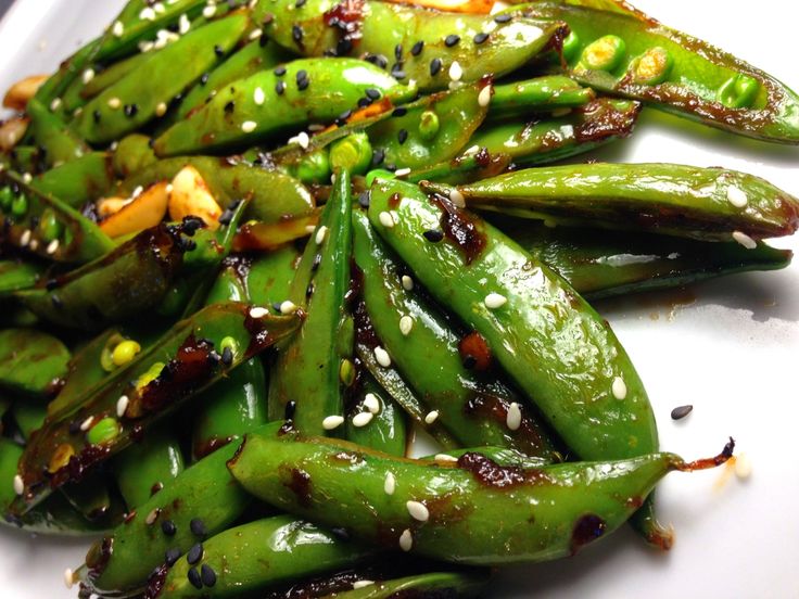 green beans with sesame seeds and seasonings on a white plate, ready to be eaten