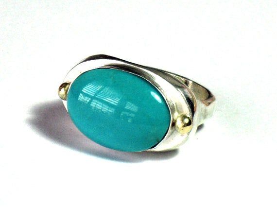 Oval Turquoise ring, Turquoise Silver, December Stone, Bezel Set, Oval Cabochon,Sterling Stone ,Jewelry Ring, Gift for HerThis classy beautiful gemstone silver gold statement ring has a beautiful oval Turquoise stone set in a sterling bezel  with two tiny 14k solid gold balls on each side. The ring was designed and handcrafted by me. I love when the stone is vertical to the hand and I designed it accordingly. The ring is classic and beautifies the hand.Wonderful gift to yourself, or someone you December Stone, Rings Turquoise, Jewerly Ring, Large Dangle Earrings, Unique Silver Rings, Ring Turquoise, Turquoise Ring Silver, Gold Statement Ring, Silver Jewelry Design