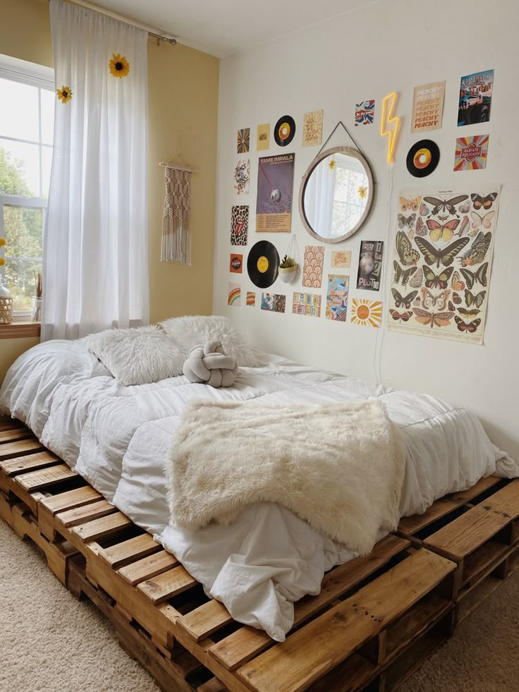 a bed made out of wooden pallets in a room with pictures on the wall