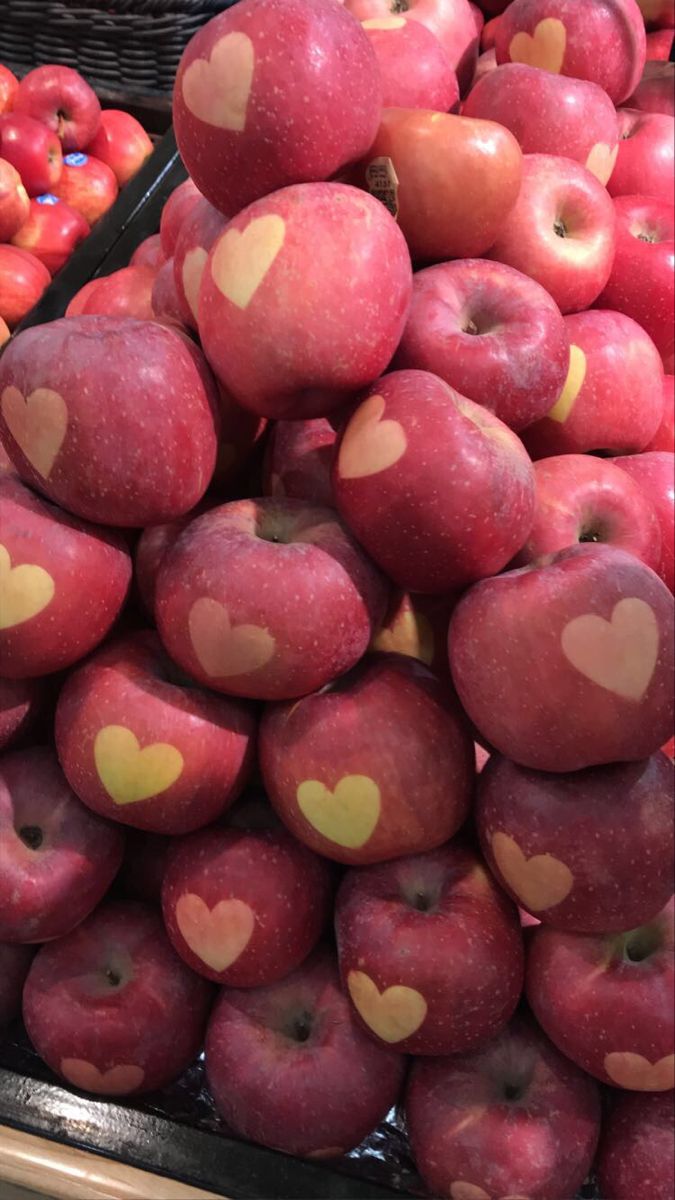 apples with hearts painted on them in a grocery store