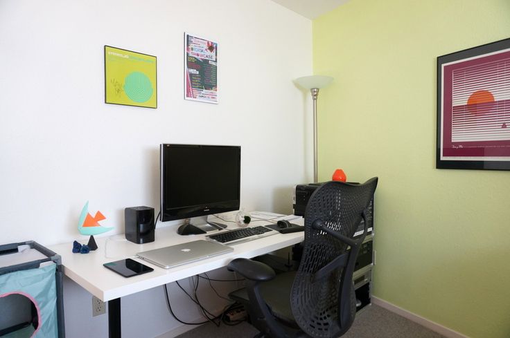 a desk with a computer monitor, keyboard and mouse next to a black office chair