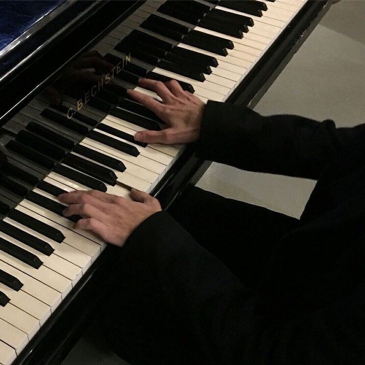 two hands are playing the piano together