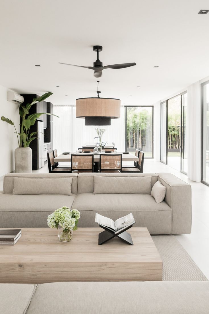 a living room filled with lots of furniture and a ceiling fan in the middle of it