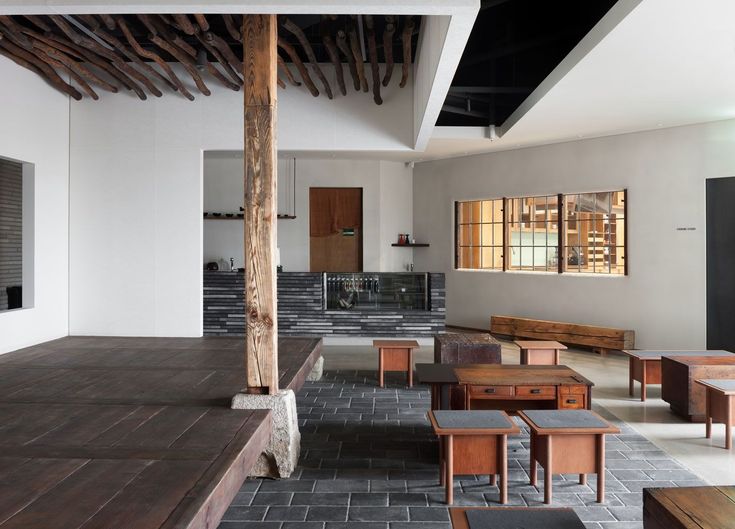 an empty room with wooden tables and benches