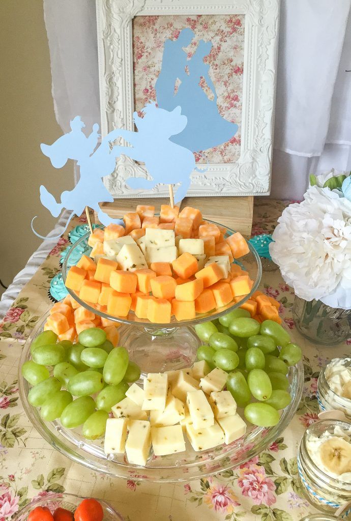 an assortment of cheeses and fruits on a table