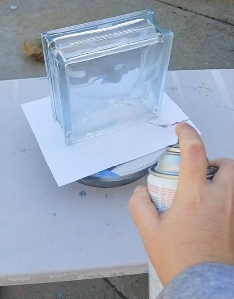 a person is painting a glass block on top of a piece of paper and glue