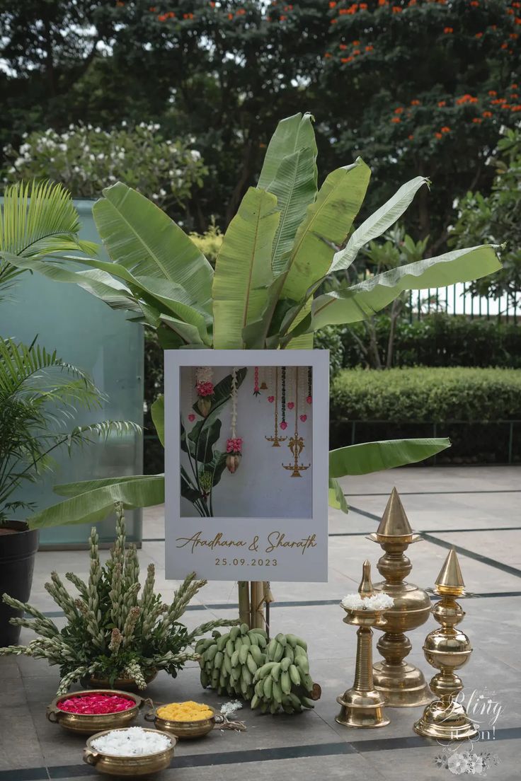 a table topped with lots of different types of flowers and plants next to a sign