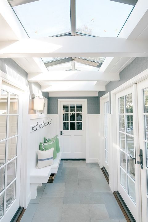 a white door and some windows in a room with skylights on the side of it