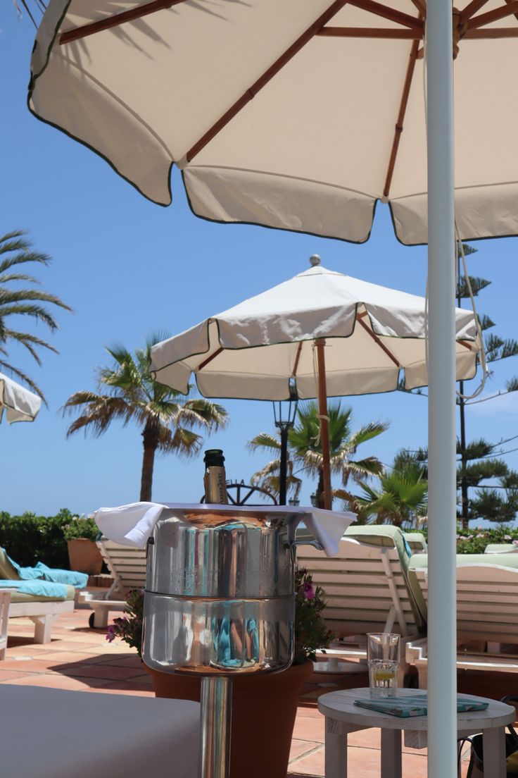 there are many umbrellas and chairs on this beachside area, but no one is in the photo