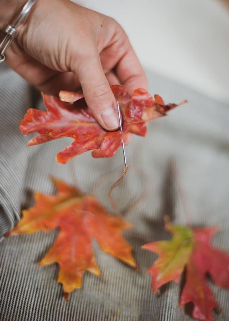 a person is holding some leaves in their hand and they are all falling off the ground