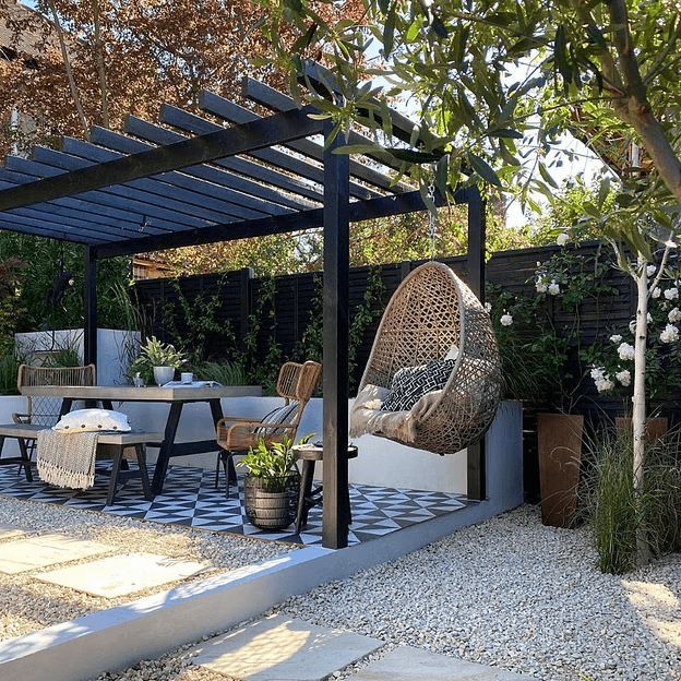 an outdoor dining area with chairs, table and hanging hammock in the middle