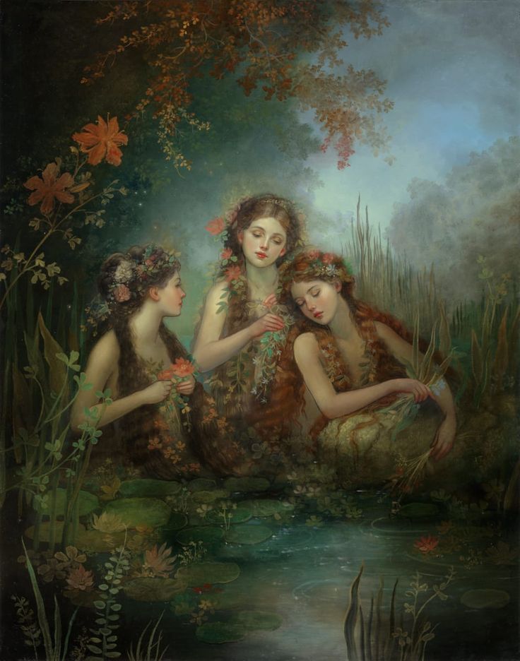 three women are sitting on the bank of a river and one is holding her hands together