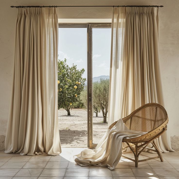 a chair sitting in front of an open window with curtains on it's sides