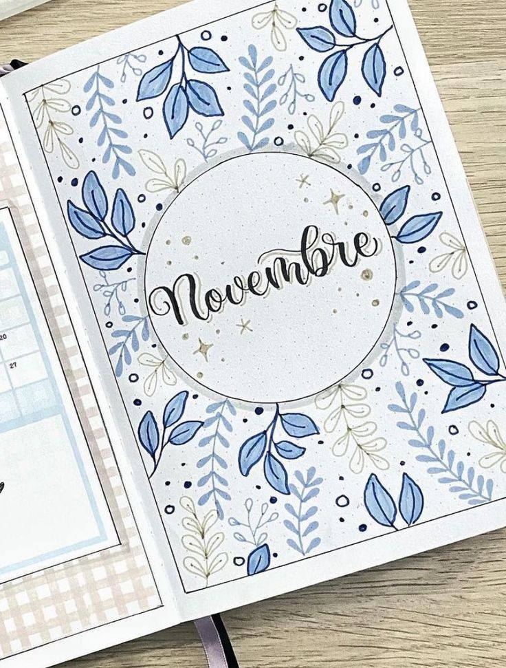 an open notebook with the word november written on it and some papers next to it