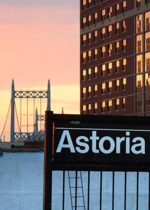 a sign that is in front of a building with a clock tower behind it and the word asteria written on it