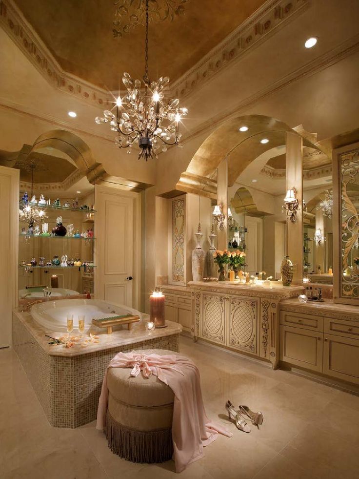 a fancy bathroom with chandelier, bathtub and candles on the countertop