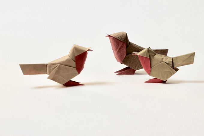 two origami birds sitting next to each other