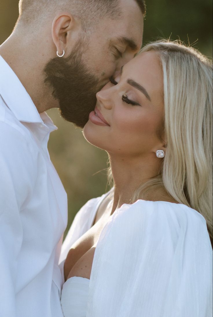 a man and woman kissing each other in front of the camera with their eyes closed