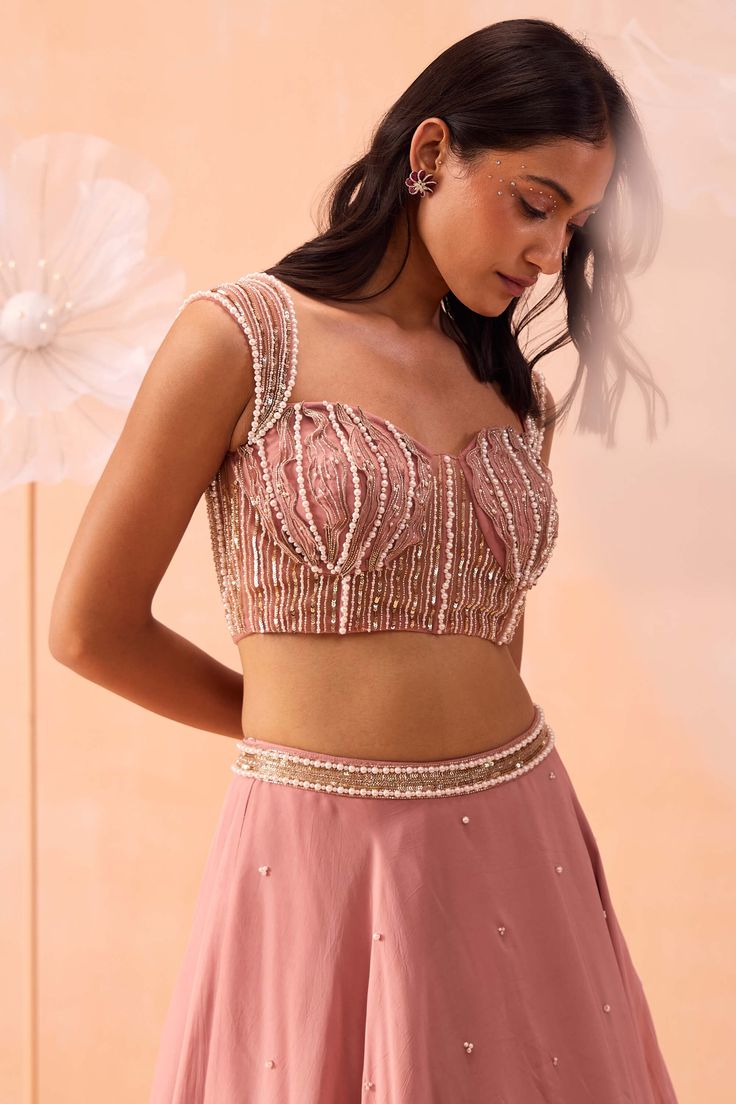 Make a stunning impression with this blouse featuring all-over 3D applique work, embellished with pearls and zari detailing. Paired with a matching skirt and dupatta, this ensemble blends intricate craftsmanship with sophisticated design, perfect for any special occasion. Hand Embellished Pink Sets, Floor-length Party Wear Sets With Pearl Embroidery, Pearl Embroidered Floor-length Party Sets, Pearl Embroidery Floor-length Party Sets, Festive Party Sharara With Pearl Embroidery, Designer Saree Sets With Pearl Embroidery, Party Wear Lehenga With Pearl Embroidery For Reception, Party Wear Sharara With Pearl Embroidery, Fitted Sharara With Pearl Embroidery For Designer Wear