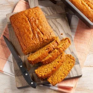 a loaf of bread sitting on top of a wooden cutting board next to a knife