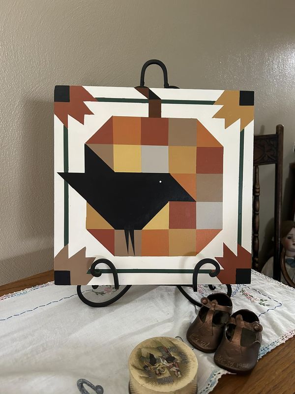 a pair of brown shoes sitting on top of a wooden table next to a painting