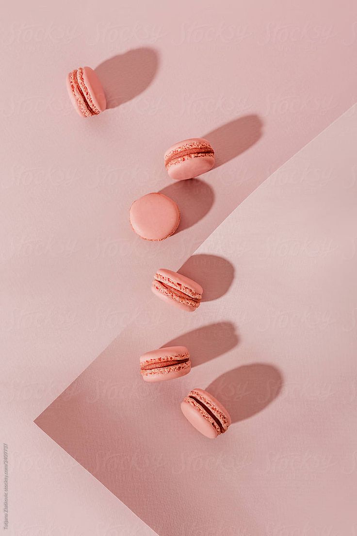 three pink macaroons sitting on top of a white table next to each other