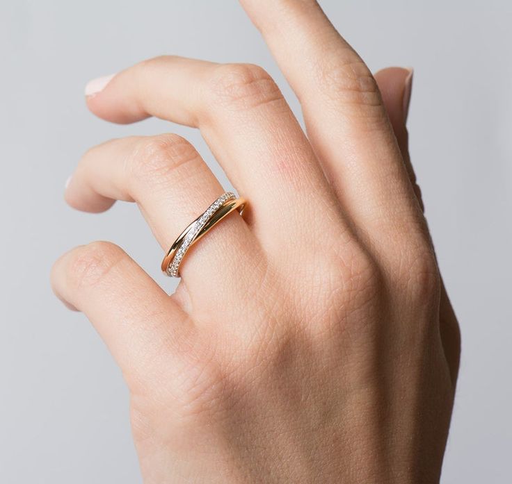 a person's hand with a ring on their left thumb and one finger in the air