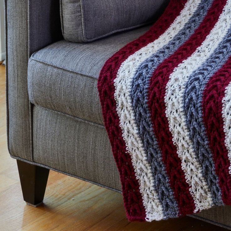 a gray couch with a red, white and blue blanket on it