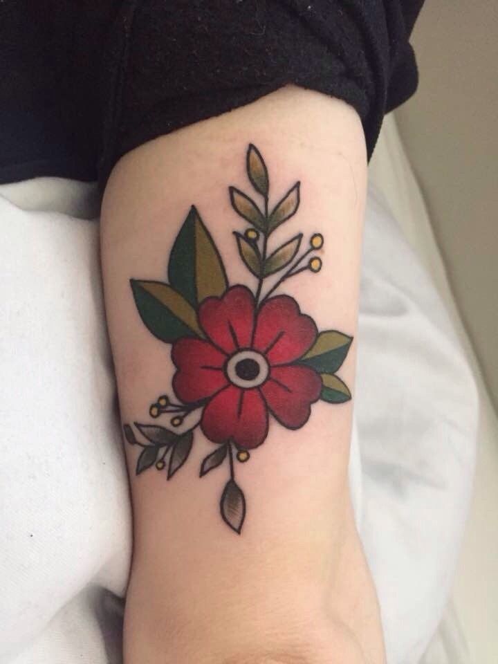 a woman's arm with a red flower tattoo on the left side of her leg