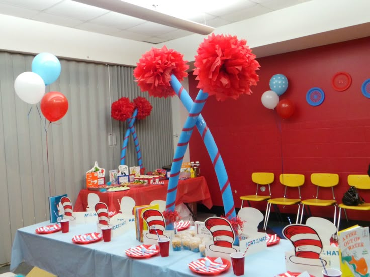 a dr seuss themed birthday party with balloons and table cloths on the tables