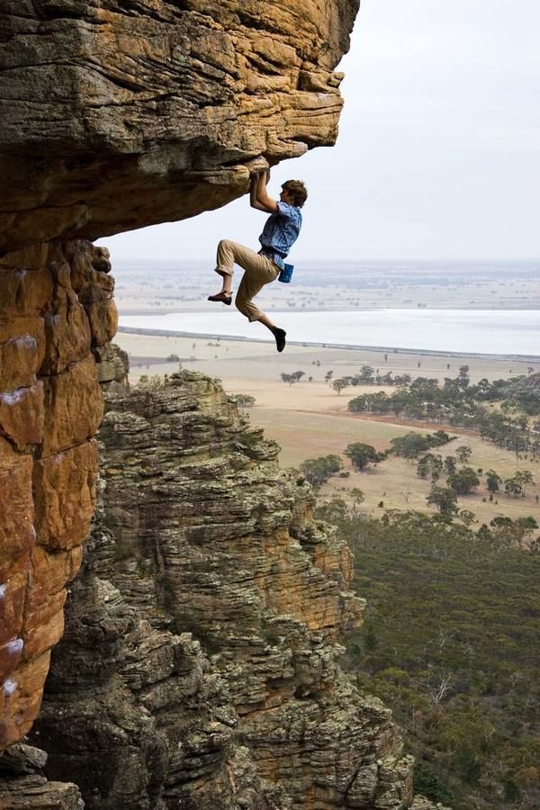 a man climbing up the side of a cliff