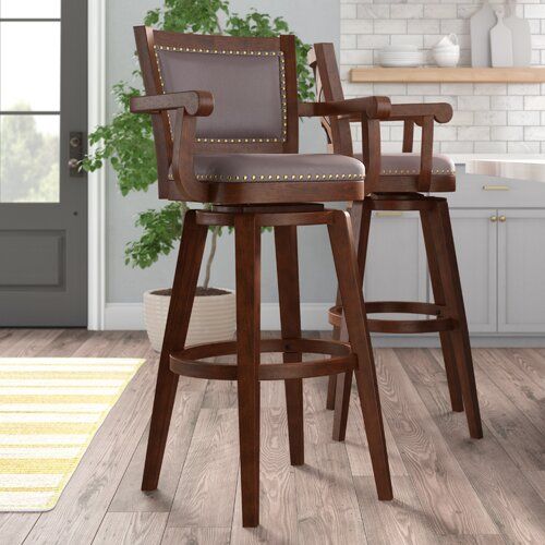 two wooden barstools with leather seats in a kitchen