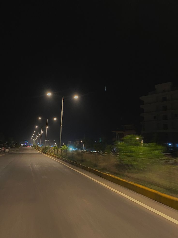 an empty road at night with street lights