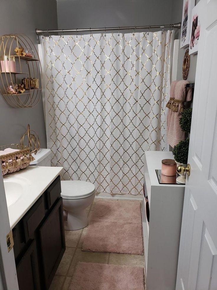 a white toilet sitting next to a bathroom sink under a shower curtain in a bathroom