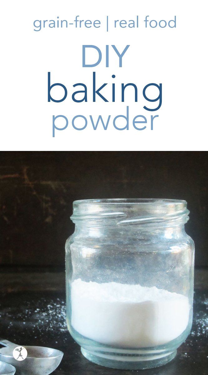 a glass jar filled with baking powder next to two spoons