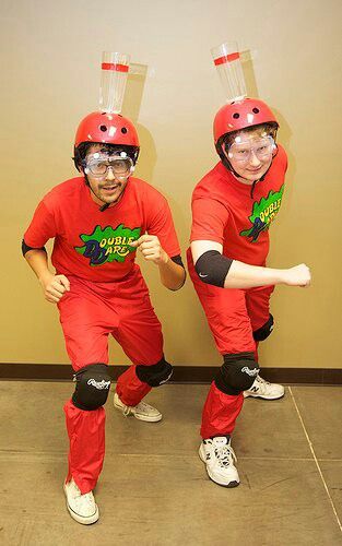 two people dressed in red are posing for the camera with helmets on their heads and arms