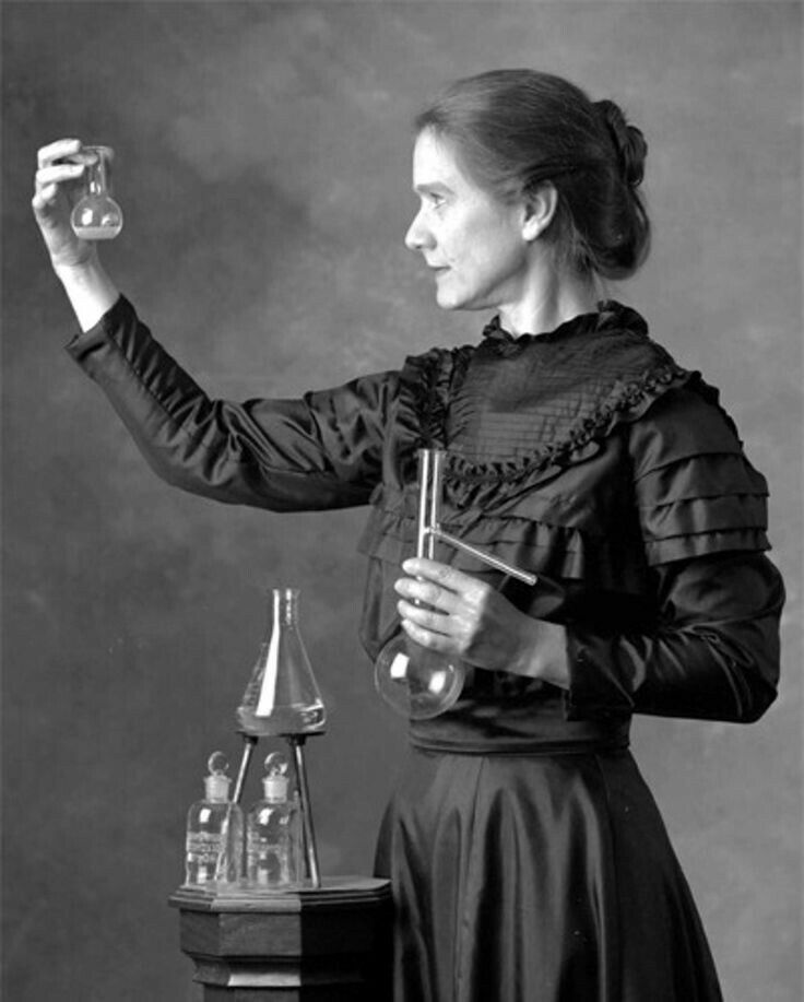 an old photo of a woman holding something in her hand