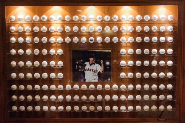 a baseball player's uniform is on display in a wooden case with lights around it