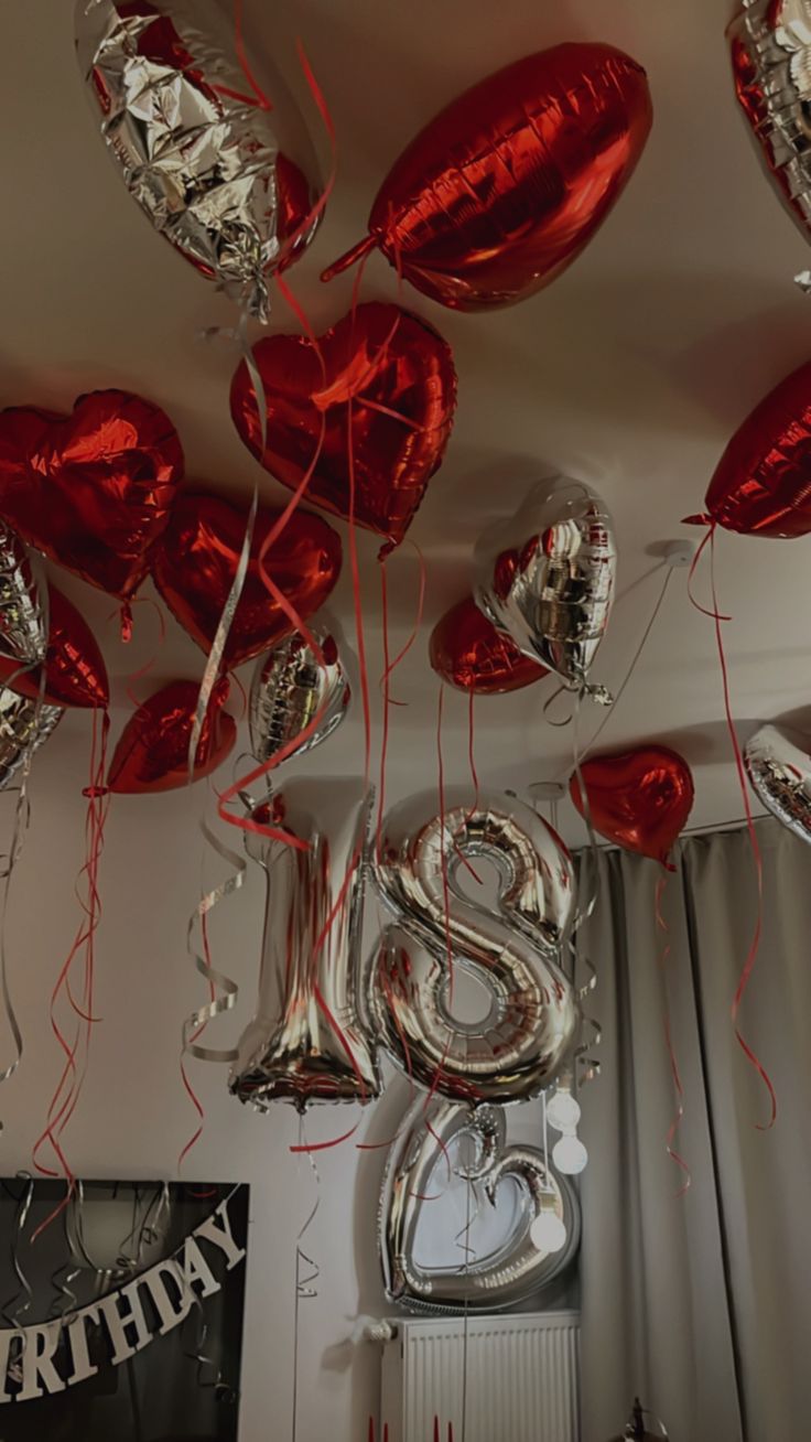 red and silver balloons are hanging from the ceiling