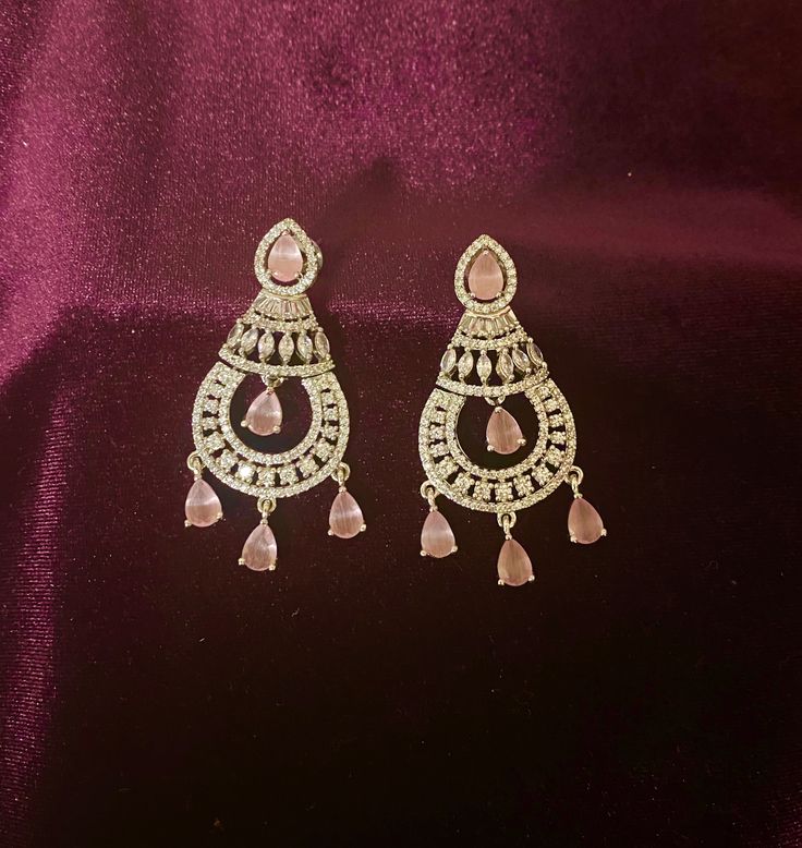 Elevate your Indian outfits or party gowns with these stunning Pink CZ Silver finish AD Earrings. The cubic zirconia stones add a touch of sparkle to any look, making you feel confident and glamorous. These earrings are the perfect accessory for any special occasion. Length -5 cm Jewellery Care- Keep the jewelry dry, avoid heat and contact with perfumes & water. Diamond White Diamond Earrings For Party, Pink Diamond Earrings With Accents For Wedding, Pink Diamond Earrings With Diamond Accents For Wedding, Diamond White Bridal Earrings With Diamond Accents For Parties, Elegant Cubic Zirconia Bridal Earrings For Evening, Diamond White Chandelier Earrings With Diamond Accents For Party, Diamond Drop Earrings For Party, Dazzling Diamond Accented Earrings For Festive Occasions, Dazzling Festive Earrings With Diamond Accents