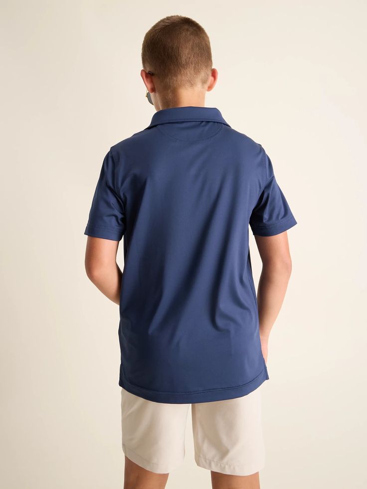 A polo so extremely stretchy and breathable, you’ll wonder how you ever performed without it. Not only does it give you a fresh look that’s perfect for hitting the course or crushing a video call, but it’s also super functional. Made from a lightweight, performance-enhancing fabric that’s anti-bacterial, moisture wicking, UPF 50+ (we’re not done), anti-static, and ultra stretchy. Mix that with a loose fit that can be tucked in or left out, you’ll be Cool and comfortable through whatever life thr Navy Classic Sports Top, Classic Navy Sports Top, Navy Short Sleeve Sporty Polo Shirt, Sporty Navy Short Sleeve Polo Shirt, Navy Moisture-wicking Collared Polo Shirt, Navy Collared Moisture-wicking Polo Shirt, Navy Collared Polo Shirt With Moisture-wicking, Blue Short Sleeve Polo Shirt With 4-way Stretch, Sporty Solid Color Golf Polo Shirt