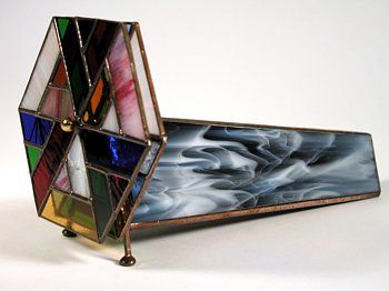 a multicolored stained glass table lamp on a metal stand with one section open