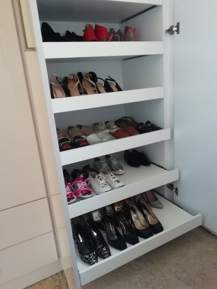 there is a closet with many pairs of shoes on the shelves and one pair of shoes in the bottom shelf