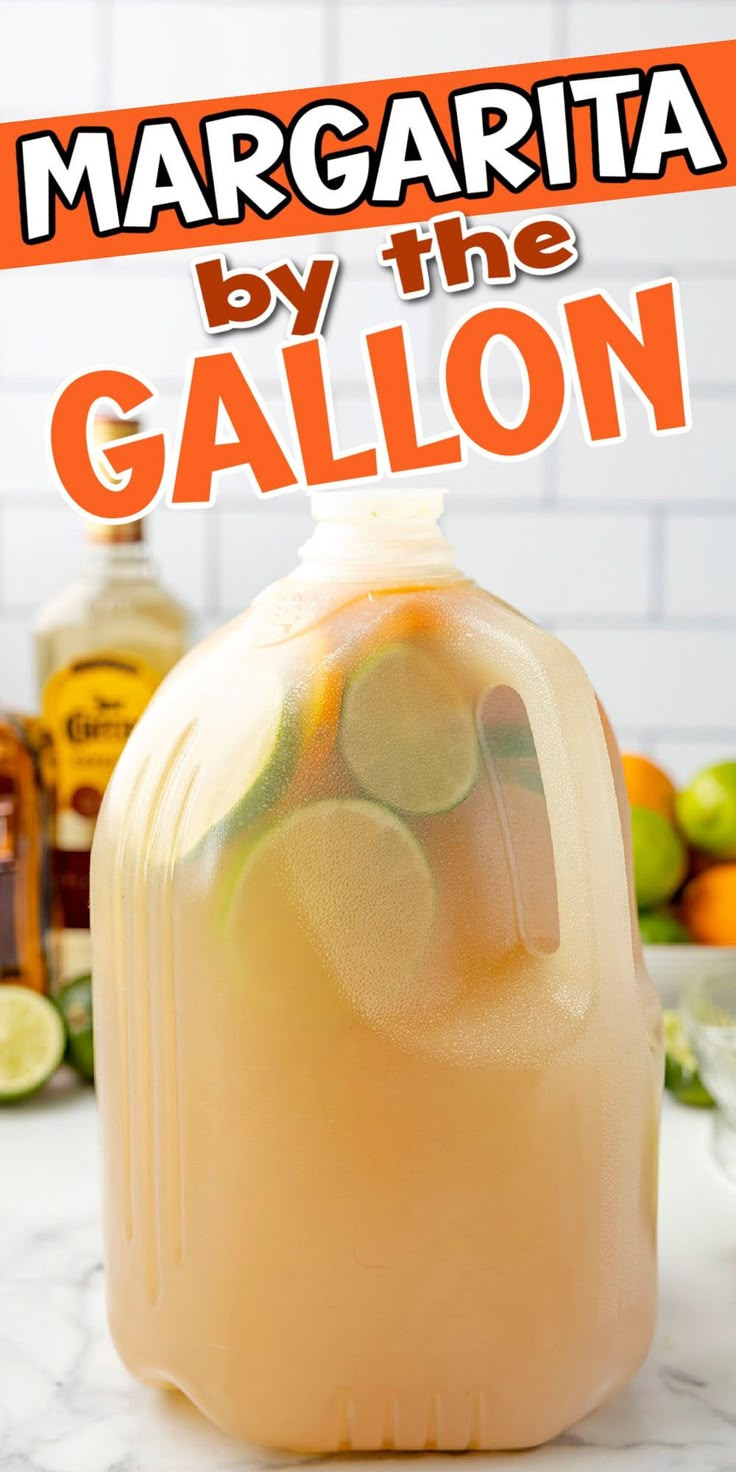 margarita by the gallon on top of a counter with limes and oranges in the background